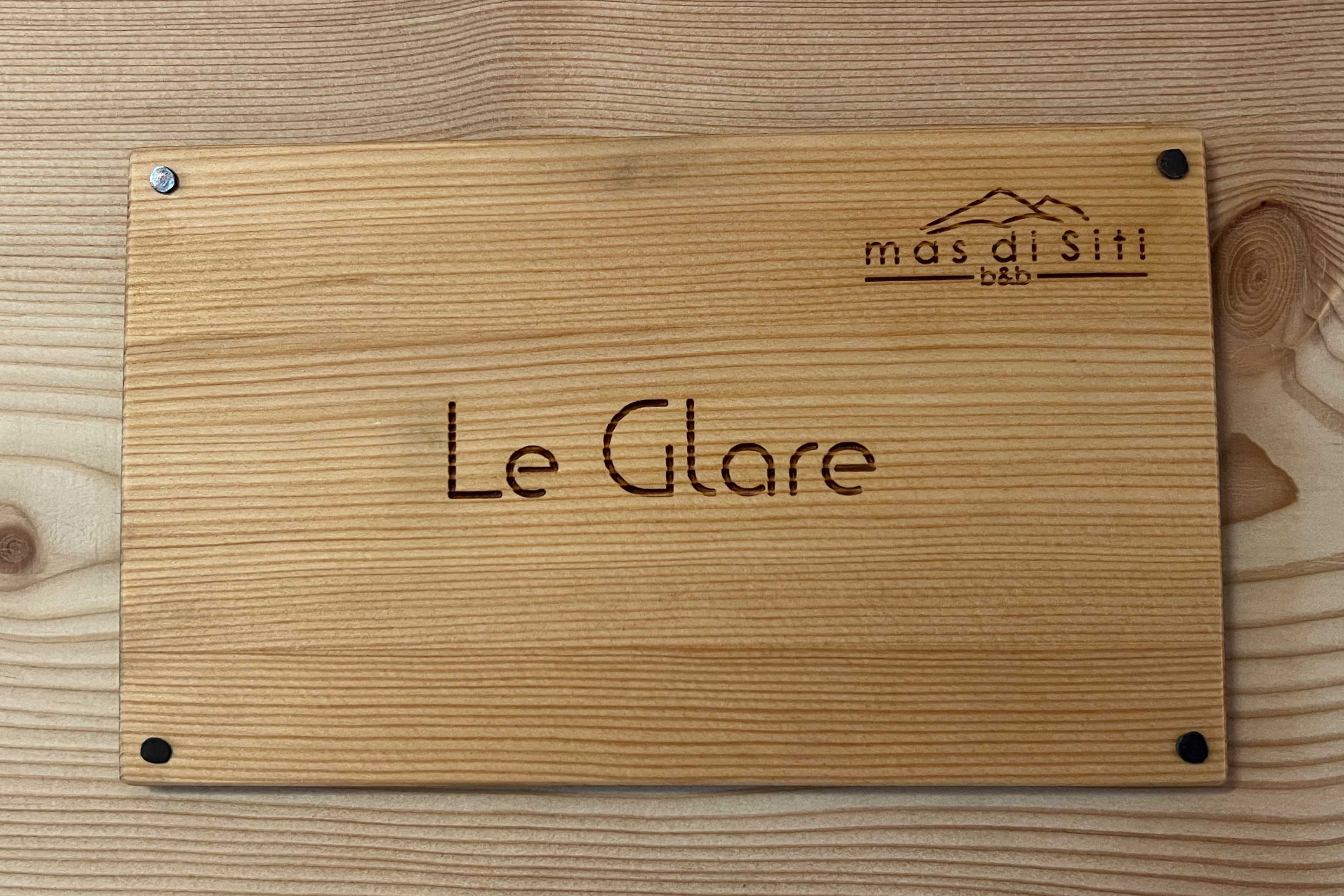 Camera Le Glare. Cartello ingresso elegante in legno.