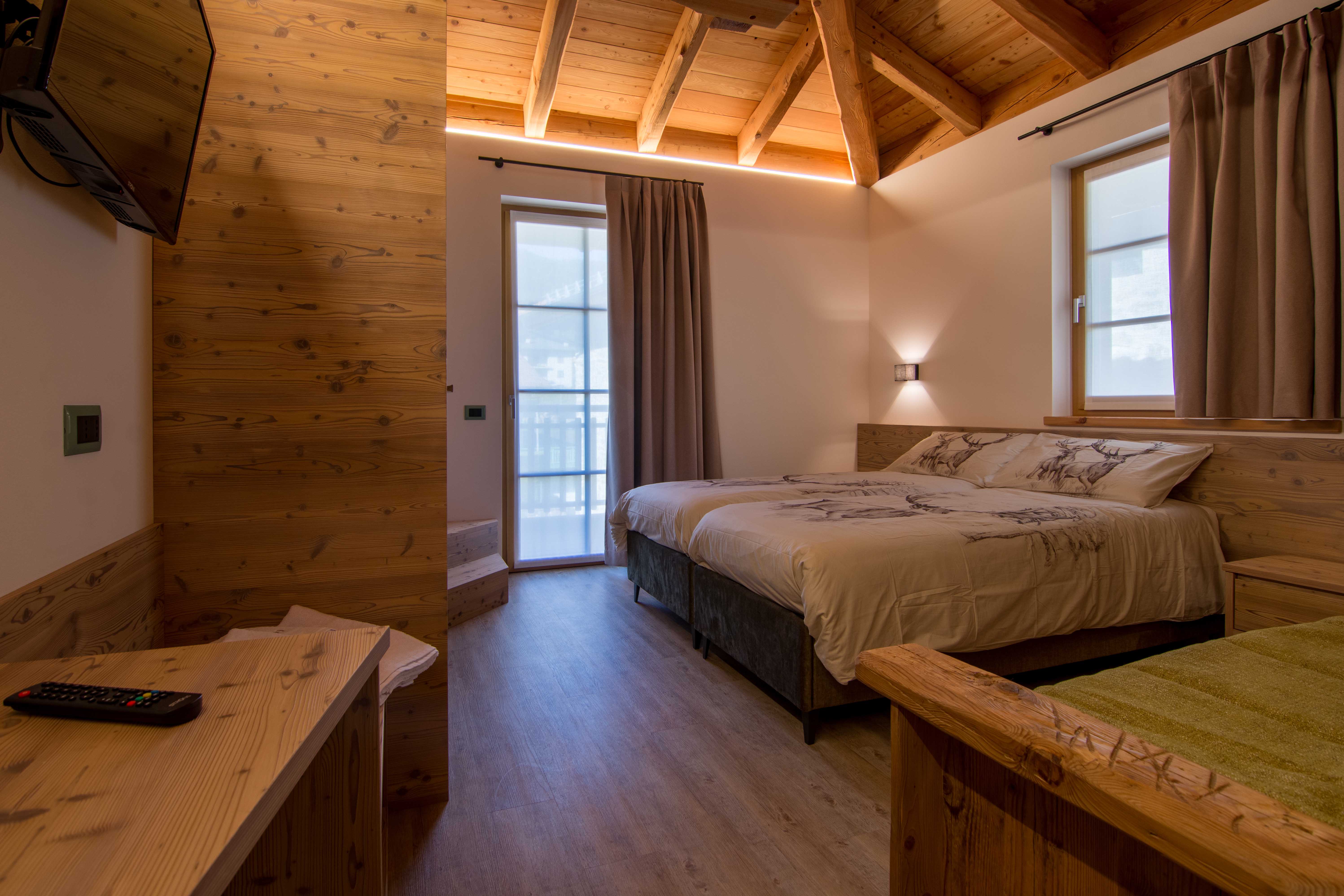 Camera Larmit. Lussuoso letto matrimoniale in spaziosa camera in legno.